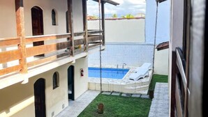 A courtyard with a swimming pool, a covered seating area, and a small garden.