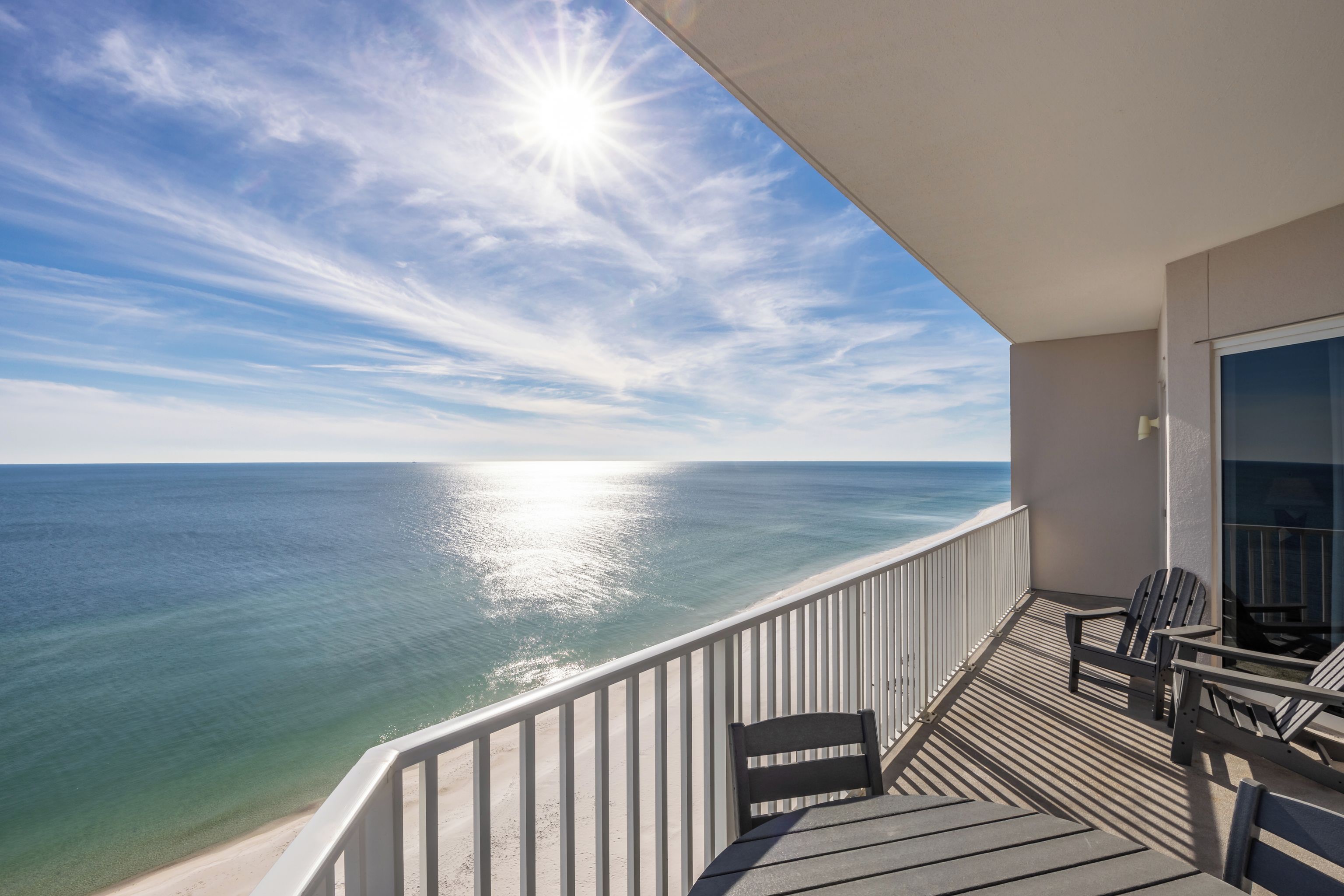 Een balkon met uitzicht op de oceaan, een tafel en twee stoelen.