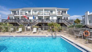 A hotel with a swimming pool, multiple balconies, and outdoor seating. - Glamorous Sunsets With THIS Westward View Of Undeveloped Park On Intracoastal (Pensacola)