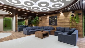 A modern lounge area with a sectional sofa, a coffee table, and a decorative ceiling with circular patterns. - Apartments near 5th Avenue with Rooftop Ocean View (Playa del Carmen)