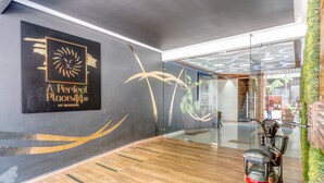 A modern interior with a wooden floor, a wall-mounted sign for 'A Perfect Place', and a glass partition with a plant wall. - Apartments near 5th Avenue with Rooftop Ocean View (Playa del Carmen)