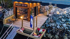 Eine Holterrasse mit einem kleinen Gebäude, Sitzgelegenheiten im Freien und einer Steinmauer.