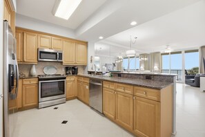 Une cuisine moderne avec des meubles en bois, des appareils en acier inoxydable et un grand îlot central.