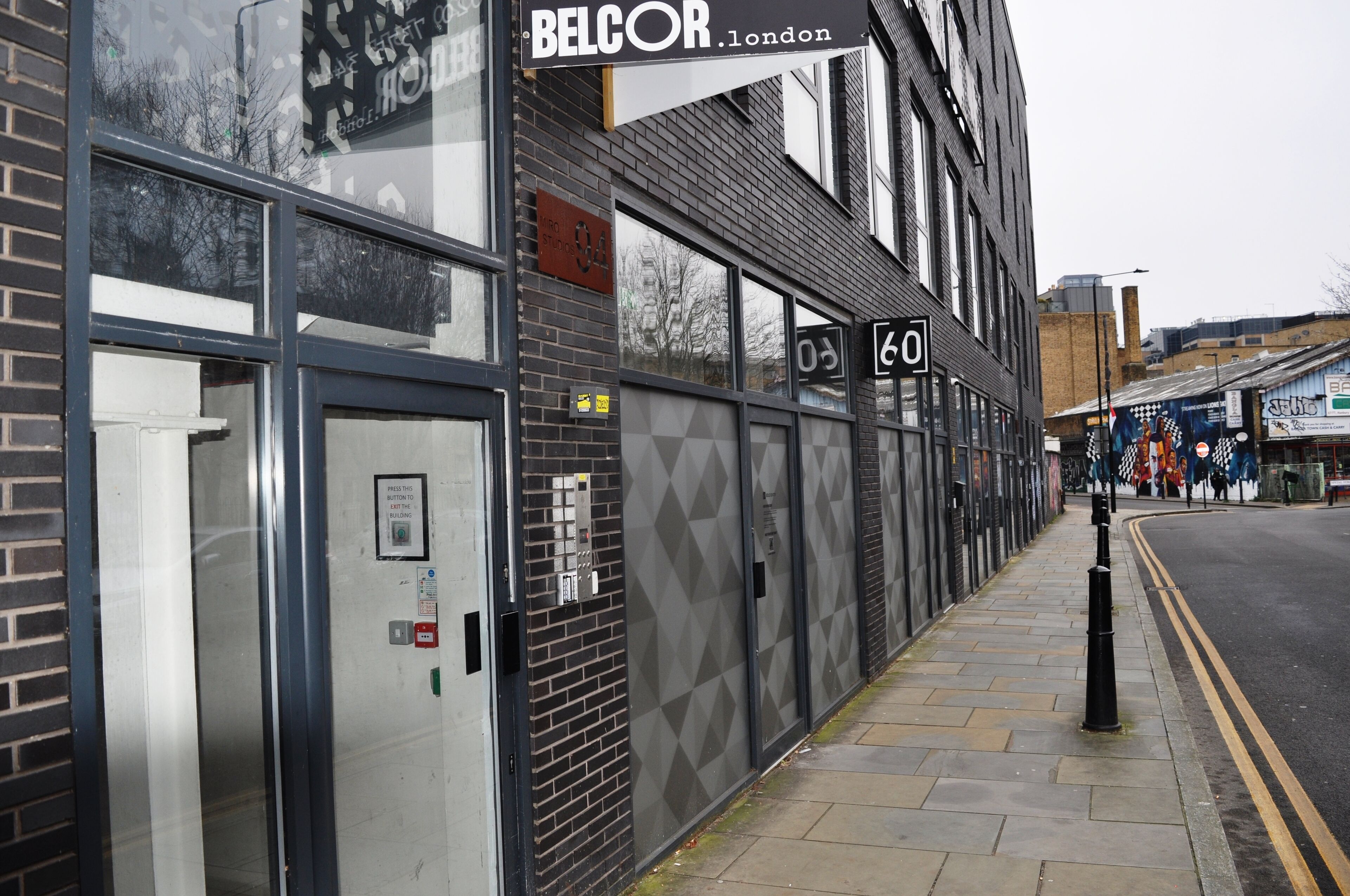 A building with a glass entrance, a sign reading "BELCOR London", and a number "60" on the wall.