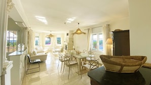 A spacious living area with a dining table, chairs, and a fireplace.
