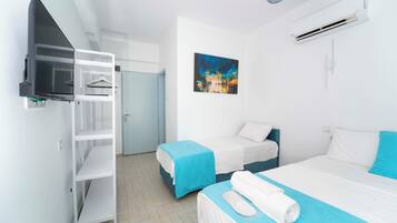 Habitación de hotel con dos camas, un armario, un cuadro y un equipo de aire acondicionado.