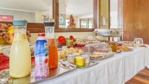 A buffet table with various food items and beverages. - Pousada Maristella (Salvador)