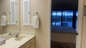 A bathroom with a sink, mirror, and two towels hanging on the wall. - 2/2.5 Waterfront condo with pools and tennis courts (Bokeelia)