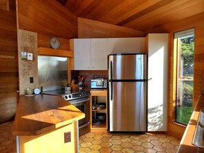 Eine kleine Küche mit einem Edelstahl-Kühlschrank, einer Mikrowelle und einem Herd.