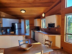 A compact kitchen with wooden cabinets, a stainless steel refrigerator, and a microwave.