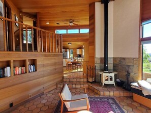 A spacious interior with a wooden staircase, a fireplace, and a dining area.