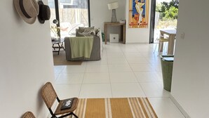 Un amplio salón con sofá, sillas, una mesa de centro y una alfombra.