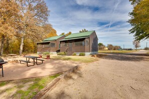 A campground with two cabins, picnic tables, and a barbecue grill. - Community Pier: Cozy Kerens Cabin! (Kerens)