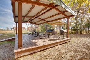 A covered picnic area with picnic tables and a barbecue grill. - Community Pier: Cozy Kerens Cabin! (Kerens)