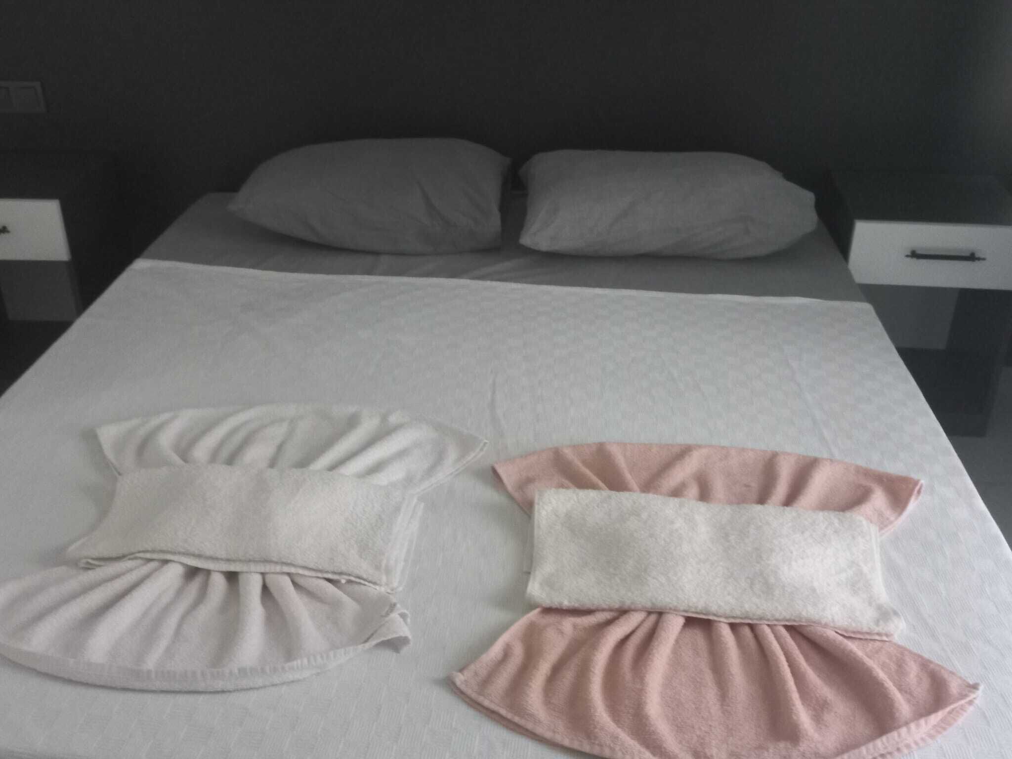 Een net opgemaakt bed met kussens en een dekbed.