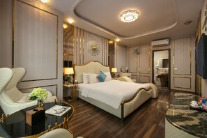 A spacious bedroom with a large bed, a sitting area with a table and chairs, and a vanity with a mirror. - BAO NGOC HOTEL LINH DAM (Hanoi)