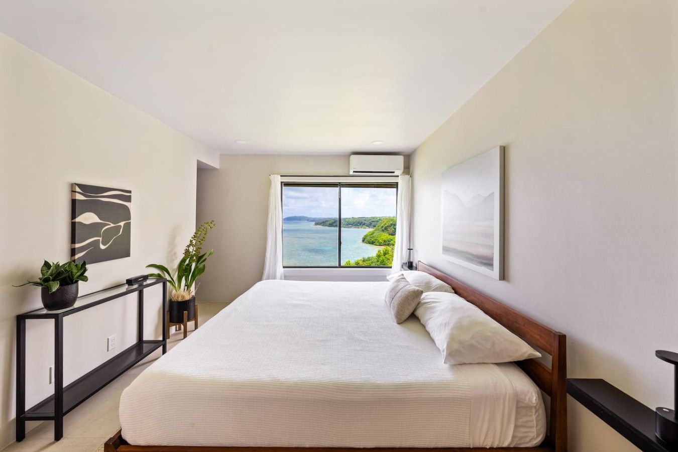 Ein Schlafzimmer mit großem Bett, Meerblick und modernem Design.