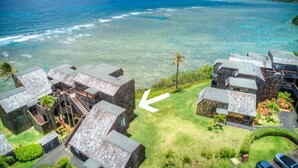 Ein Resort mit mehreren bungalowartigen Gebäuden, freiem Blick auf den Ozean und einer gepflegten Rasenfläche.
