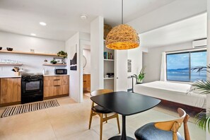 Une cuisine moderne dotée d’un four encastré, de meubles en bois et d’un coin repas avec une table ronde et des chaises.