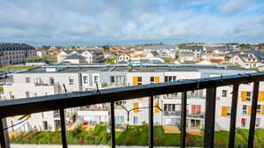 Zona residencial con edificios modernos, un balcón y vistas del barrio.