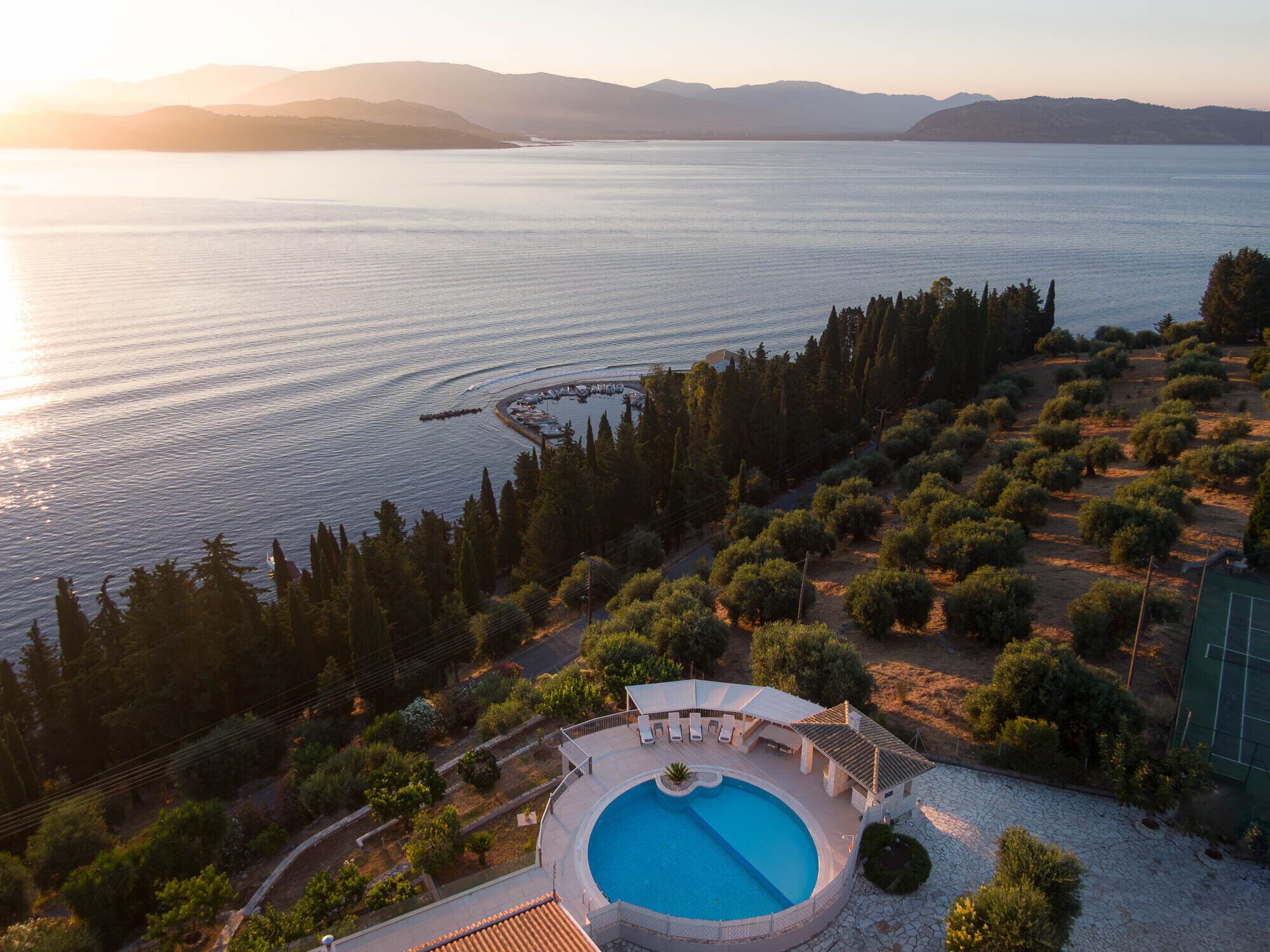 A resort with a swimming pool, surrounded by landscaped gardens and a view of the sea.