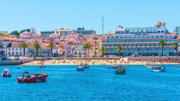 A coastal cityscape with a prominent hotel named "HOTEL BATA" and a beach area with boats and people.