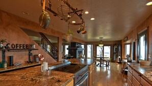 A spacious kitchen with granite countertops, stainless steel appliances, and a coffee station. - Canyonside Retreat - Park-like setting, Panoramic Views with Hot tub & Firepit!! (Buhl)