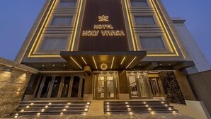 A modern hotel building with a prominent entrance, a large sign reading "HOTEL HOLY VINA SA," and a well-lit facade. - HOLY VIVASA  (Rishikesh)