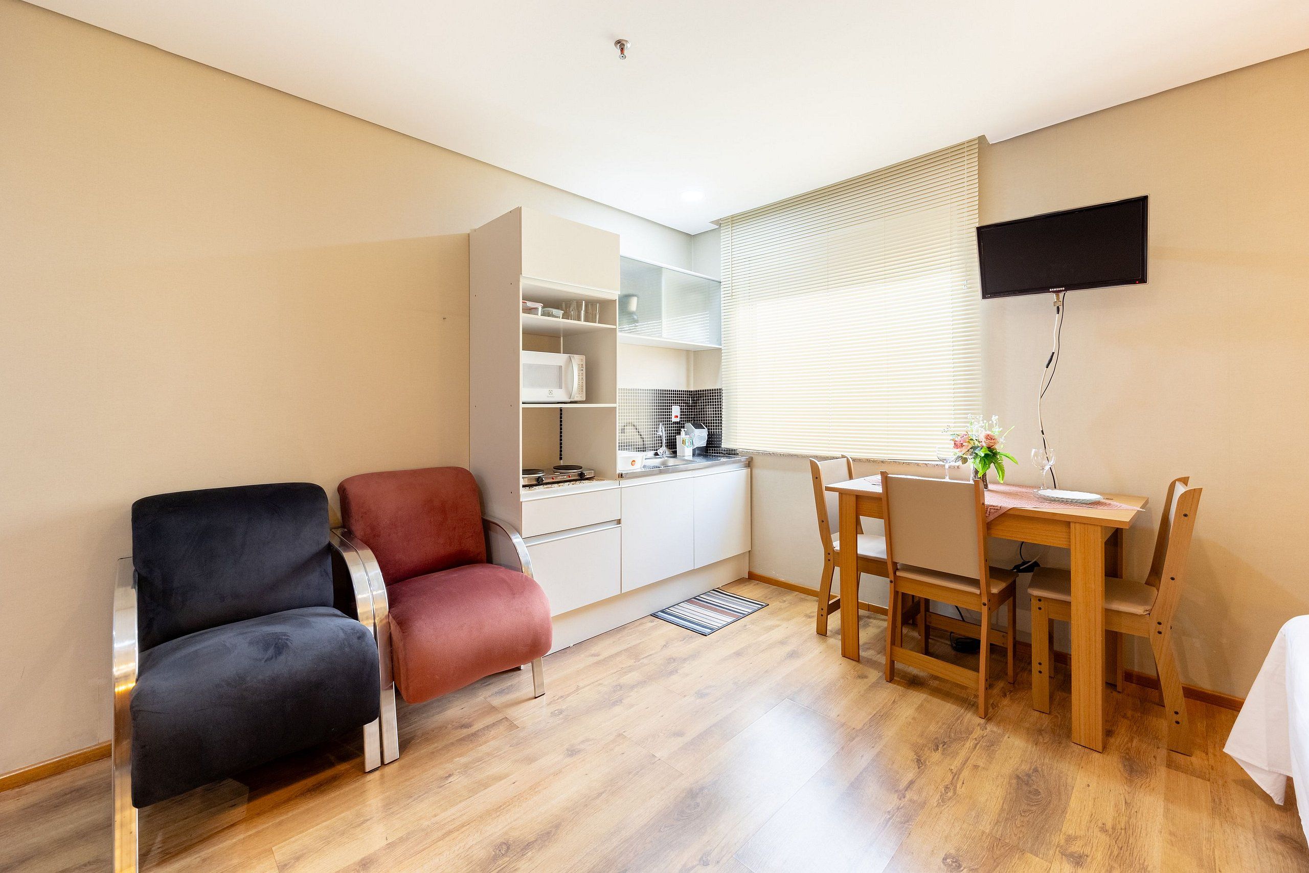 A compact living space with a kitchenette, a dining area, and seating.