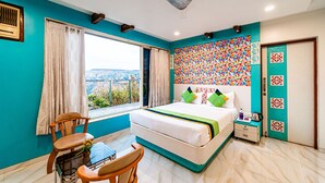A bedroom with a bed, a chair, a table, a window with curtains, and a view of the outdoors. - Treebo Raval Resort with Valley View (Wai)