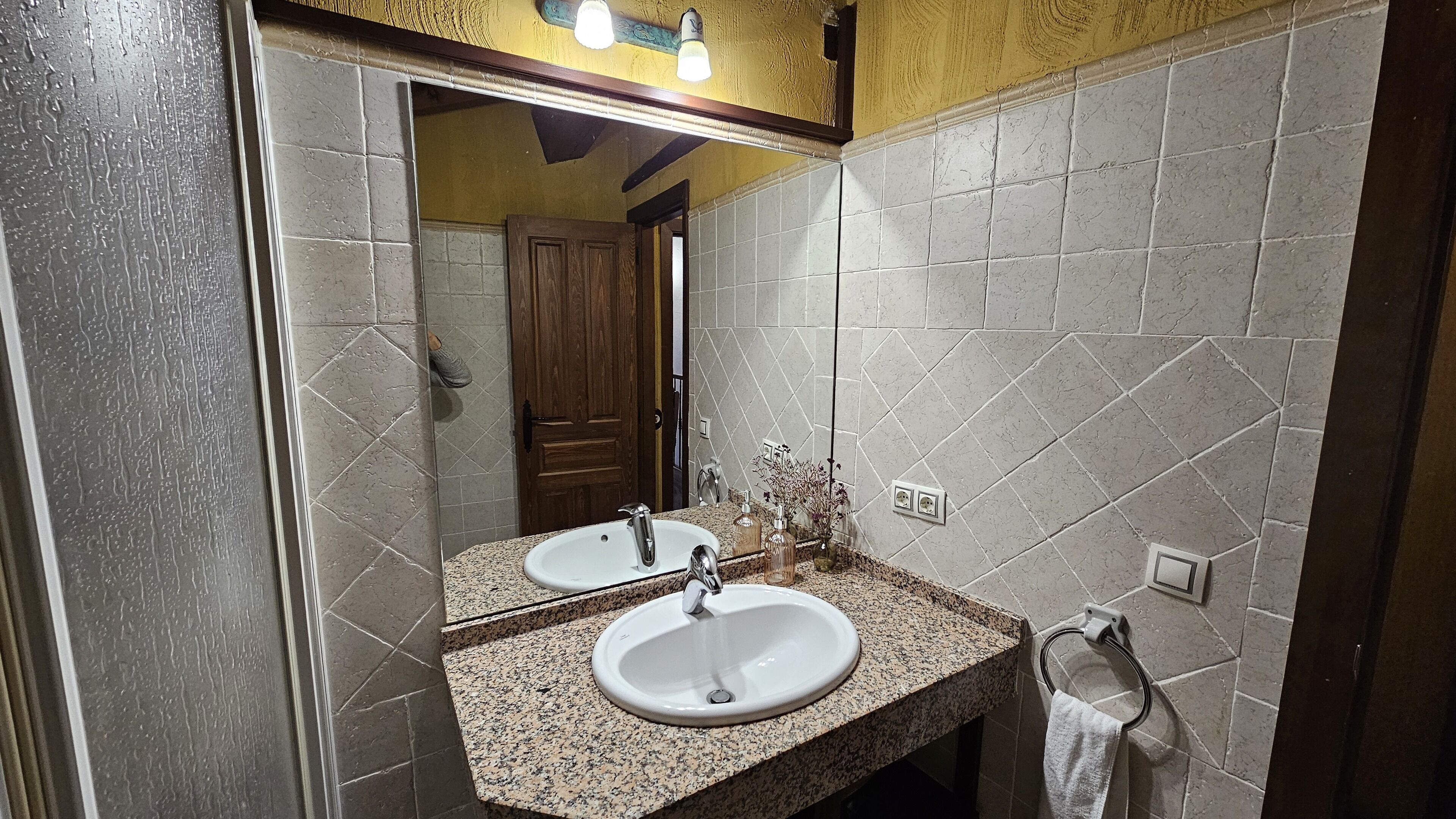 Un baño con dos lavamanos, un espejo y un perchero para toallas.