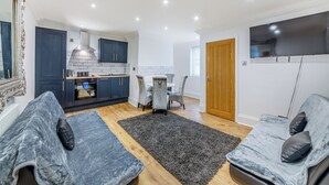 Un salon moderne avec un canapé, une table basse et un téléviseur.