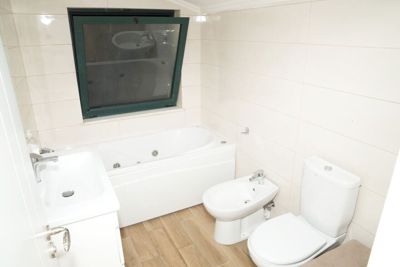 Un baño con bañera, inodoro, bidé y lavabo.