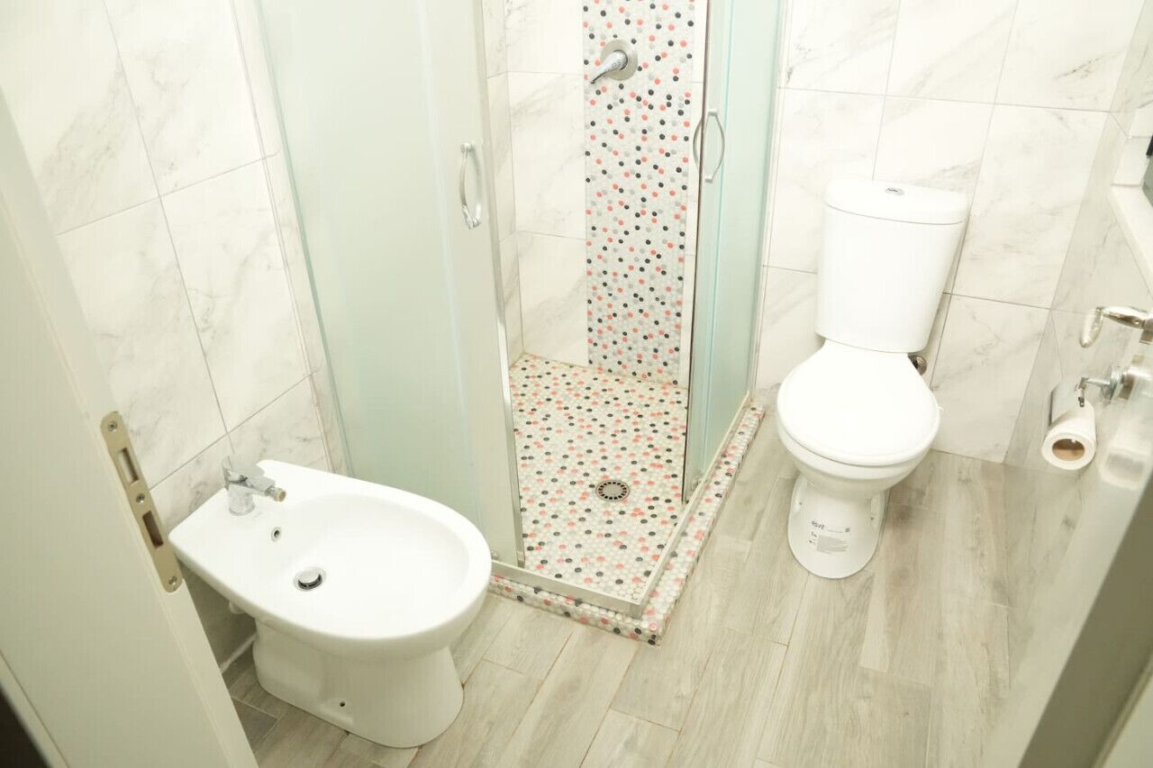 Ein Badezimmer mit Dusche, Toilette und Bidet.