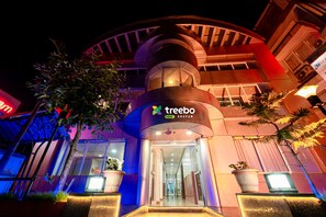 A modern building with a curved facade and a prominent entrance. - Itsy Hotels Anupam (Mahabaleshwar)