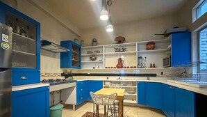 Eine Küche mit blauen Schränken, einem Holztisch und einem Teppich mit Muster.