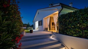 Une maison moderne avec un escalier menant à une entrée abritée.