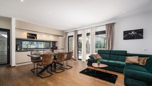Un appartement moderne comprenant un coin repas, une cuisine et un salon.