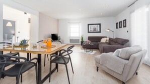 A modern living room with a dining area, a sofa, and a TV. - Beach front home in Pula (Pula)