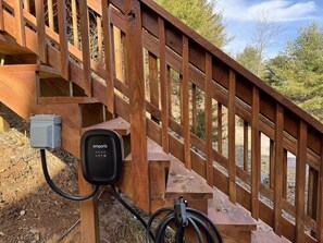 Un escalier en bois avec une boîte électrique noire et une station de recharge.
