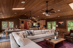 A spacious living room with a large sectional sofa, a wooden coffee table, and a fireplace.