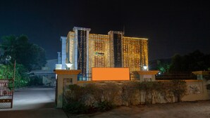 Um edifício de hotel com design moderno, com vários andares e uma entrada imponente.