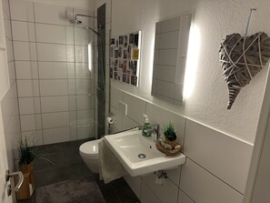 Een douche, handdoeken, zeep, toiletpapier