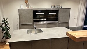 Uma cozinha moderna com ilha central, eletrodomésticos de aço inoxidável e design minimalista.