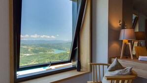 A room with a large window offering a scenic view of a lake and mountains. - Luxurious home in Pazin (Pazin)