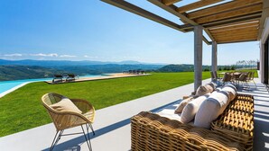 A luxurious outdoor seating area with a view of a swimming pool and mountains. - Luxurious home in Pazin (Pazin)