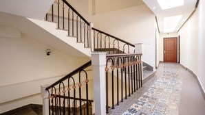 A staircase with a patterned floor and a wooden door at the end. - Itsy Hotels Meraki Grand (Gangtok)