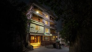 A multi-story hotel with a well-lit entrance, balconies, and a visible sign for 'Treebo'. - Itsy Hotels Meraki Grand (Gangtok)