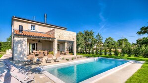 A two-story house with a swimming pool, outdoor seating, and a garden. - Gorgeous home in Sivati (Sivati)