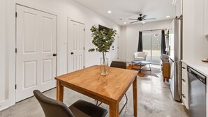 Une cuisine moderne équipée d’un réfrigérateur, d’un lave-vaisselle et d’un coin repas avec une table et des chaises en bois.